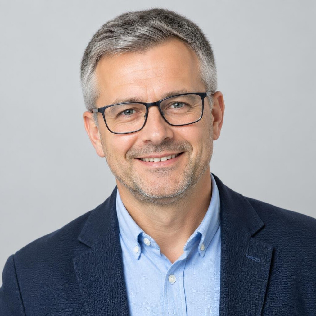 Studio portrait of a Polish man with glasses and a friendly smile