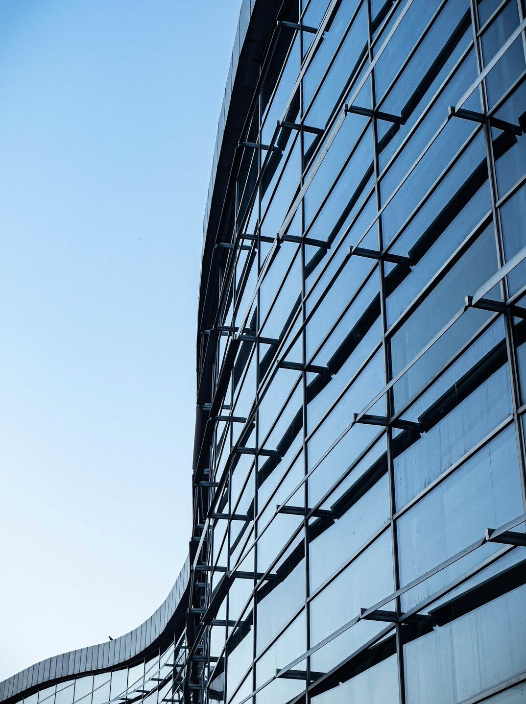 Modern glass office building exterior under a clear sky