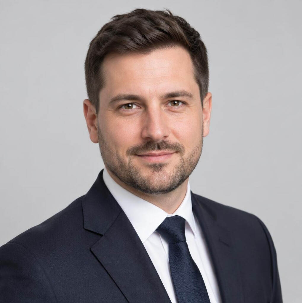 Studio portrait of a Polish man with short dark hair in a suit